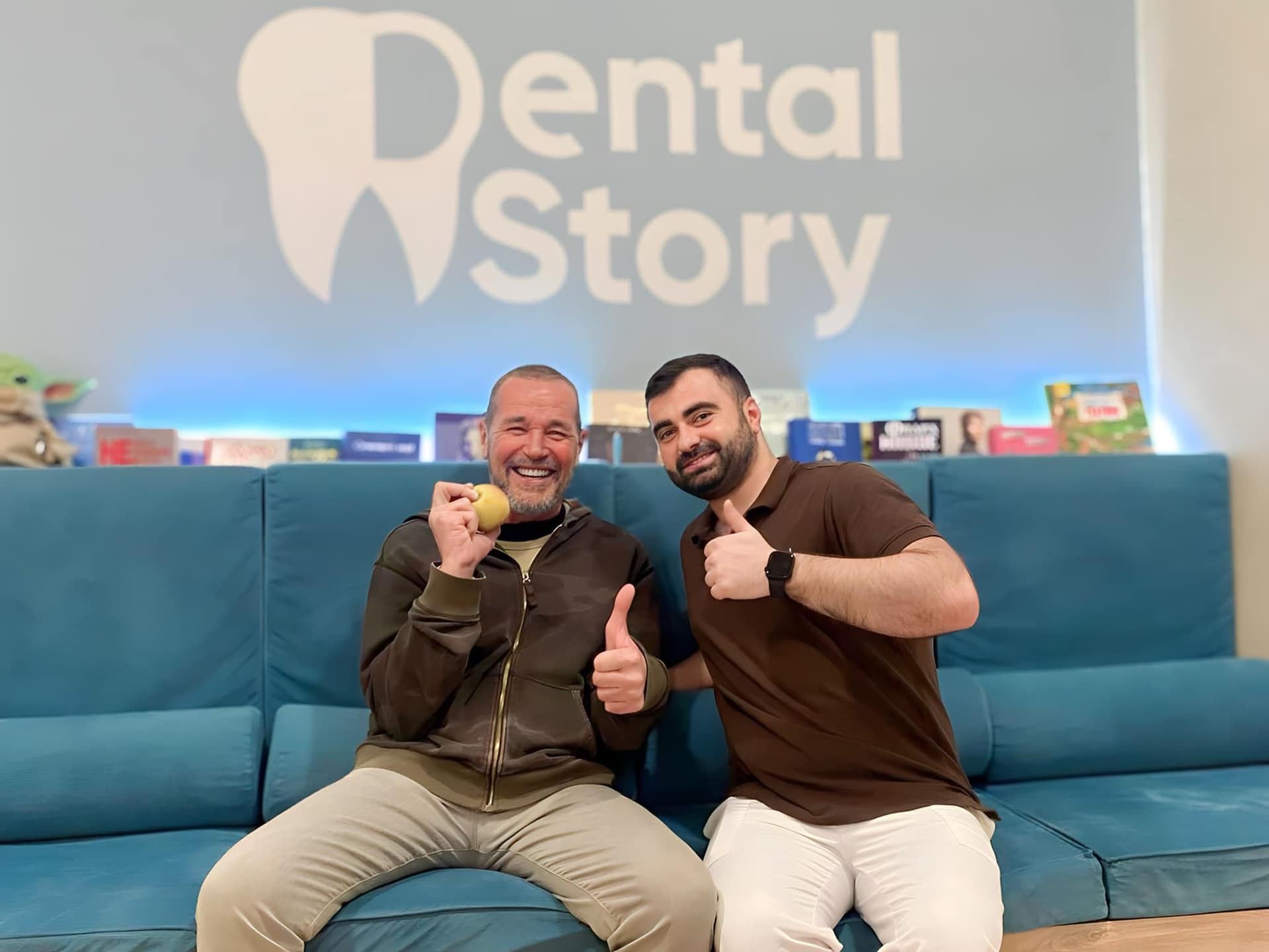 Двоє чоловіків у зоні очікування Dental Story на синьому дивані